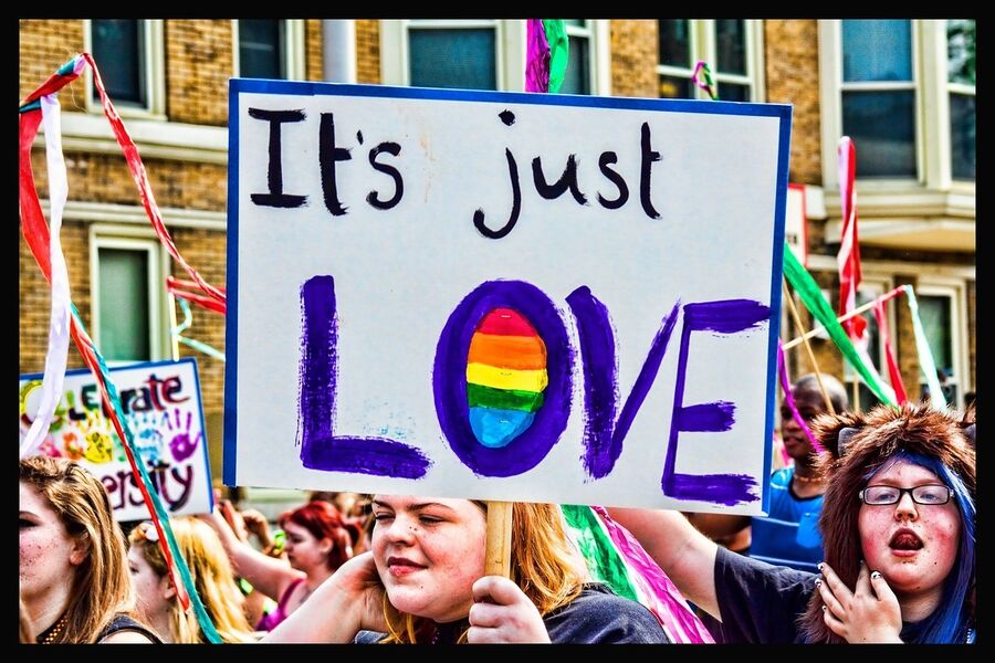 Person ved Pride festival holder et skilt med teksten "Its just love" 