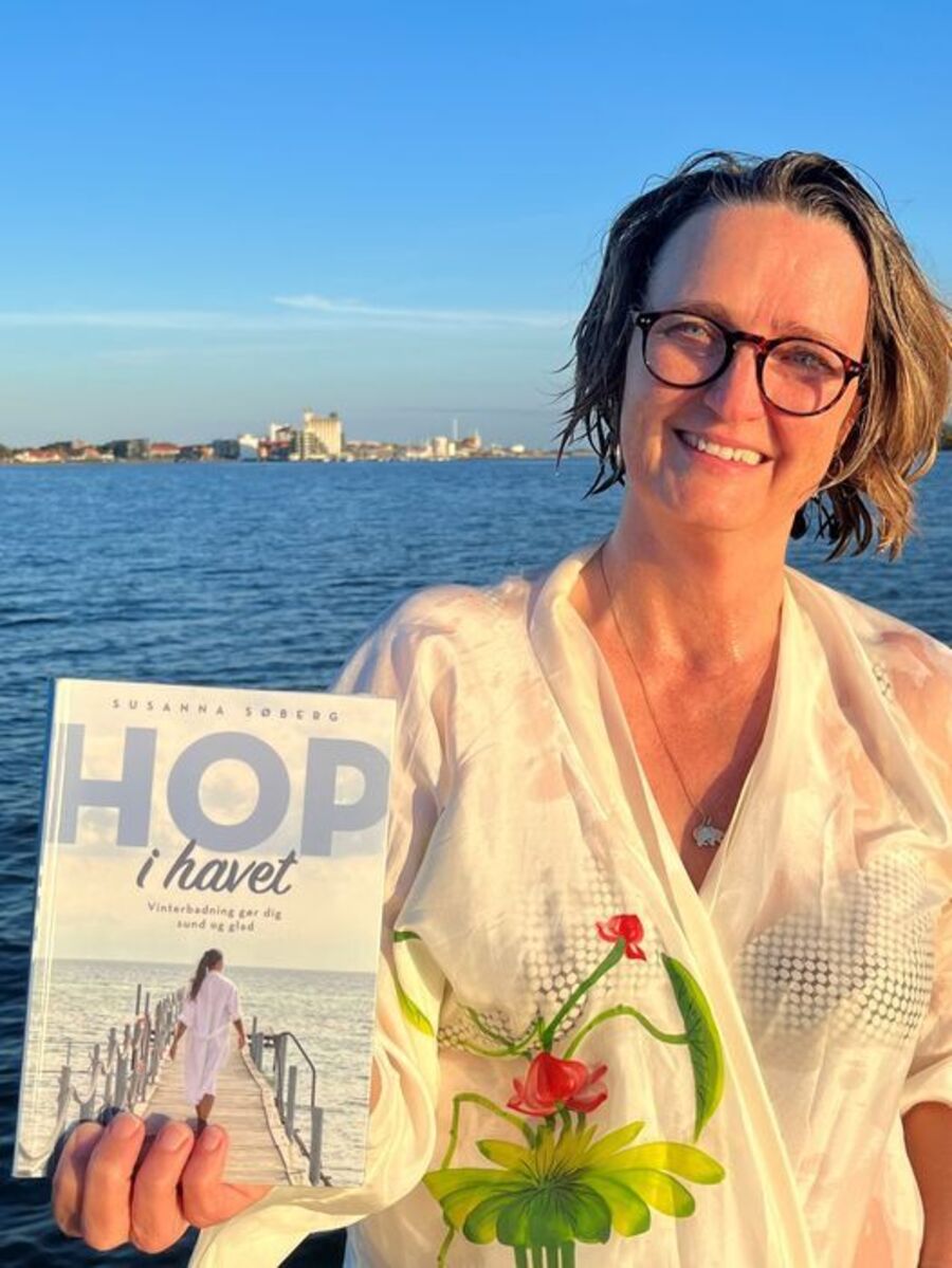 Pia holder bogen "Hop i havet" efter en frisk tur i vandet ved Guldborgsund