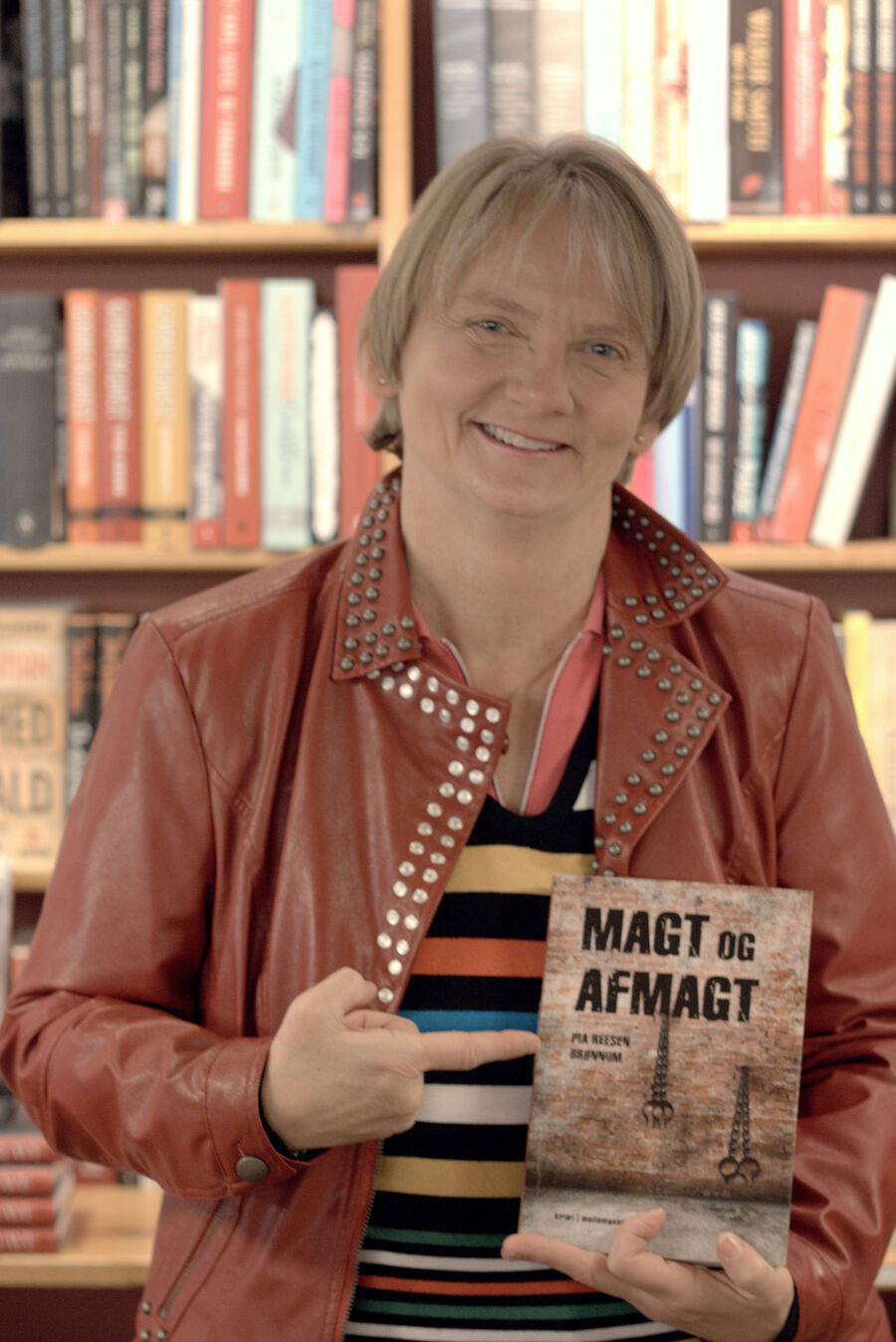 Smilende Pia E. Brønnum Reesen holder sin bog med titlen Magt og afmagt