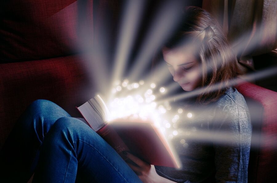 Pige ser i bog hvor magisk lys skinder ud