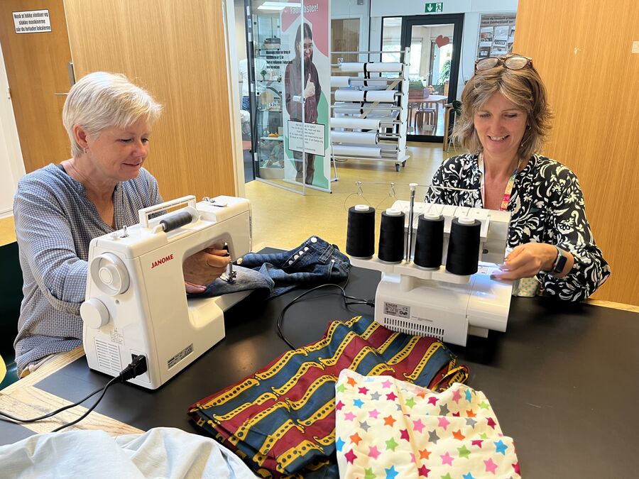 Bibliotekarerne Susanne og Tine syer på symaskiner
