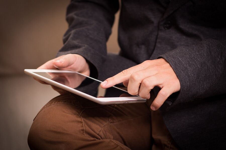Person sidder og benytter en tablet