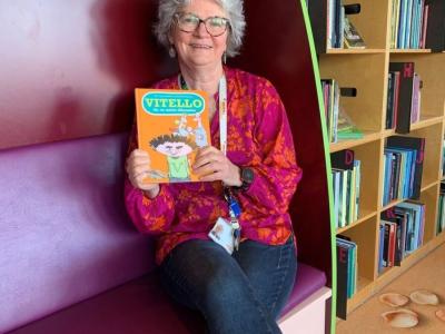 Vibeke sidder i sofa med bogen Vitello