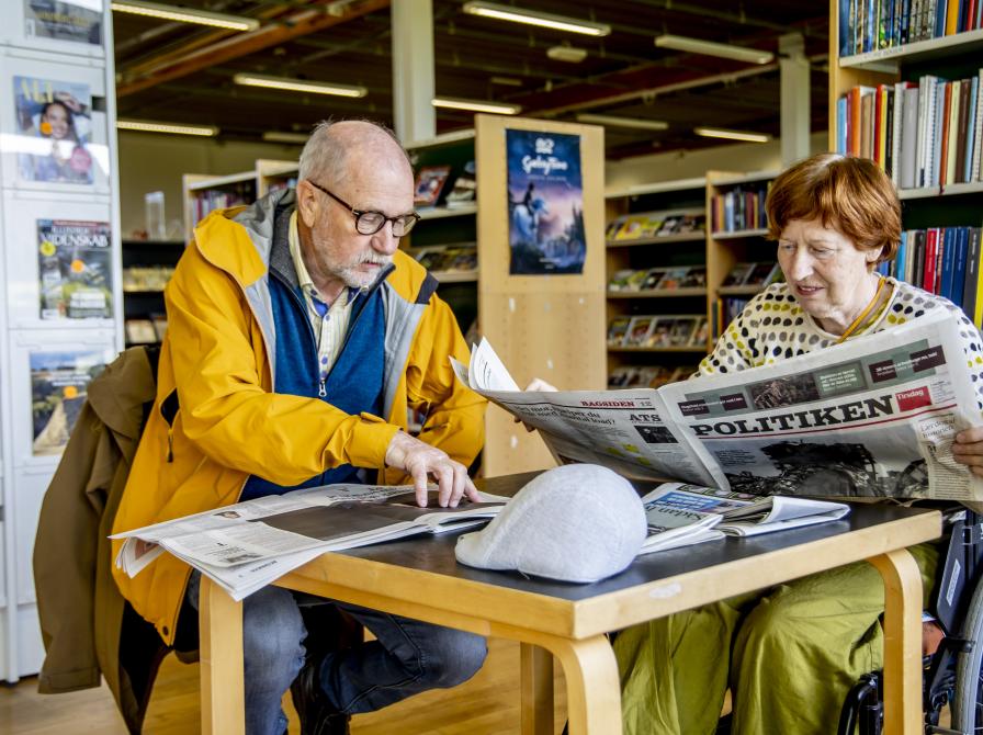 to brugere læser avis på biblioteket